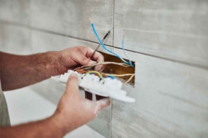 Electrician reparing and wall socket